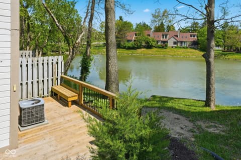 Outdoor living area at 6048 S Bay Drive, Indianapolis, IN — Serene waterfront deck with mature trees and pond views.