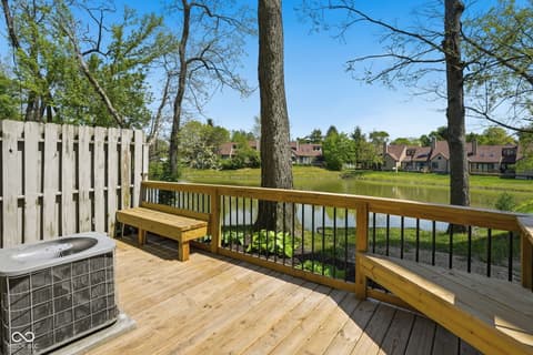 Outdoor living area at 6048 S Bay Drive, Indianapolis, IN — Stunning waterfront deck with mature trees and lake views.