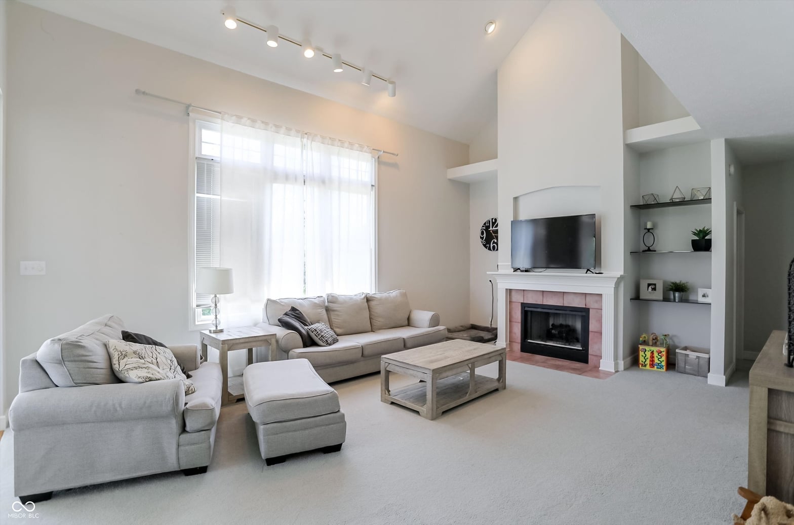 Bright contemporary living room with fireplace and built-ins.