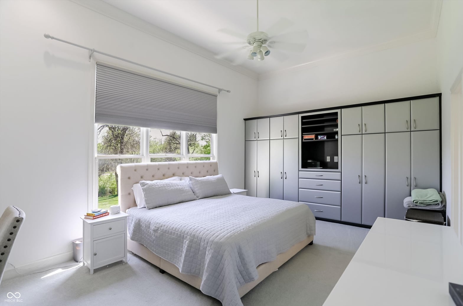 Bright modern primary suite with extensive built-in storage.