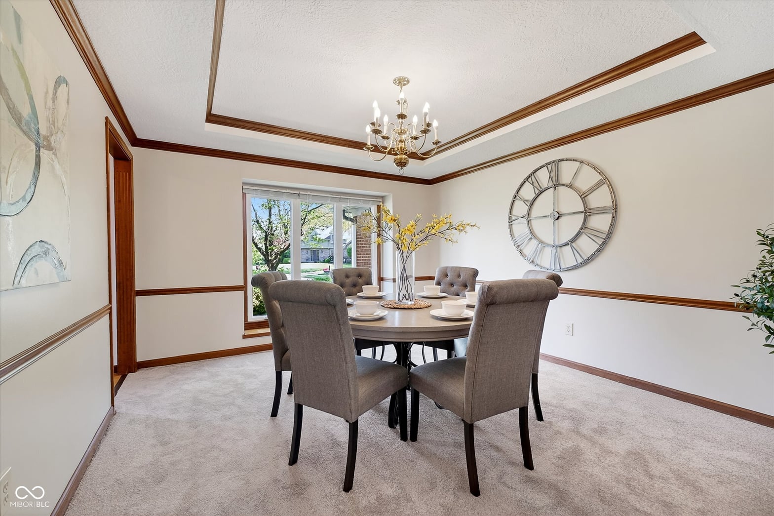 Elegant dining room with coffered ceiling and natural light.