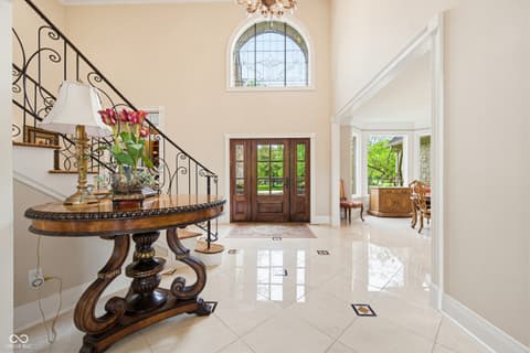 Foyer at 7436 Glenvista Place, Fishers, IN — Elegant foyer with marble floors and curved staircase.