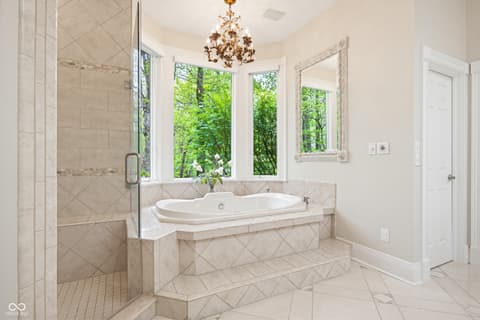 Primary bathroom at 7436 Glenvista Place, Fishers, IN — Luxurious primary bath with soaking tub and nature views.