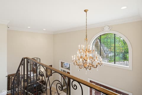 Foyer at 7436 Glenvista Place, Fishers, IN — Elegant foyer with crystal chandelier and arched window.
