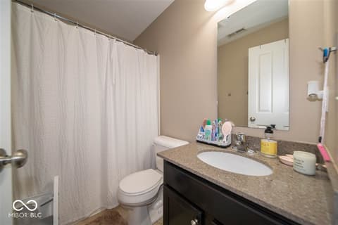 Bathroom at 14128 Stoney Shore Avenue, McCordsville, IN — Updated bathroom with granite counters and dark vanity.