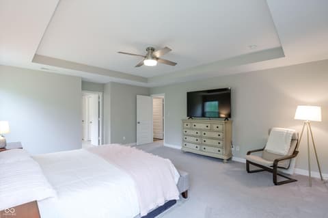 Primary bedroom at 17462 Cavalcade Circle, Noblesville, IN — Spacious primary suite with tray ceiling and sitting area.