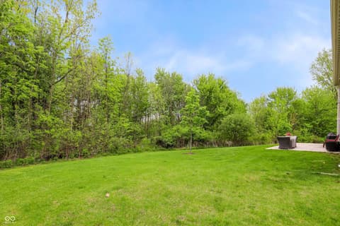 Yard at 17462 Cavalcade Circle, Noblesville, IN — Spacious level yard with mature tree privacy buffer.