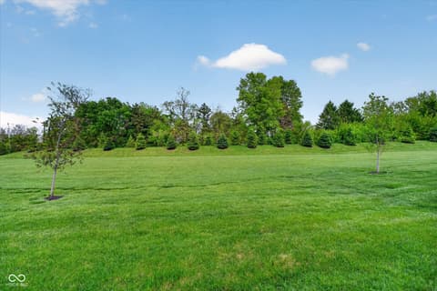 Outdoor living area at 20237 Willenhall Court, Westfield, IN — Spacious covered patio overlooking expansive manicured lawn.