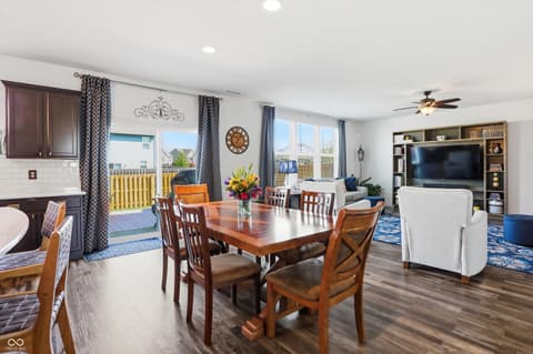 Dining room at 14680 Hinton Drive, Fishers, IN — Bright open-concept dining with wood table and patio access.