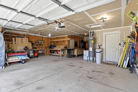 Garage at 14680 Hinton Drive, Fishers, IN — Spacious two-car garage with extensive storage shelving.