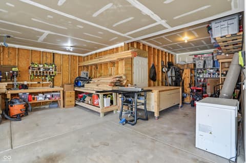 Garage at 14680 Hinton Drive, Fishers, IN — Well-organized garage with custom workbench and storage.