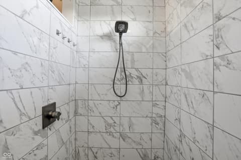 Primary bathroom at 14680 Hinton Drive, Fishers, IN — Luxurious marble shower with modern rainfall showerhead.