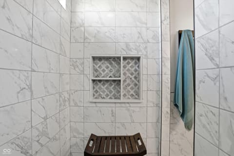Primary bathroom at 14680 Hinton Drive, Fishers, IN — Luxurious marble walk-in shower with elegant built-in niche.
