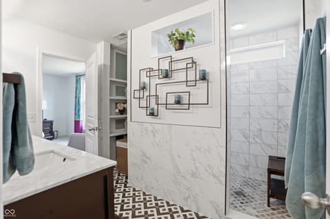 Primary bathroom at 14680 Hinton Drive, Fishers, IN — Luxurious spa-like primary bath with marble finishes.