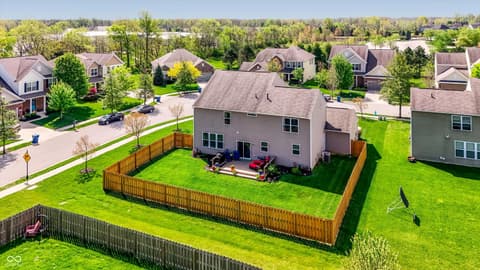 Backyard at 14680 Hinton Drive, Fishers, IN — Spacious fenced yard with mature landscaping and patio.