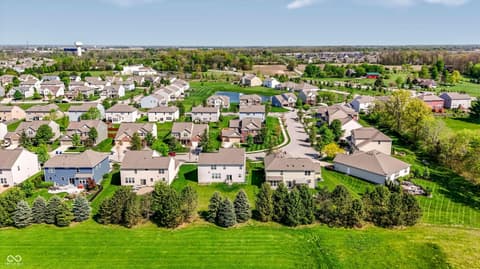 Aerial view at 14680 Hinton Drive, Fishers, IN — Established suburban community with mature trees and pond.