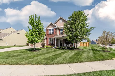 Front exterior at 14680 Hinton Drive, Fishers, IN — Charming brick home with mature landscaping and front porch.