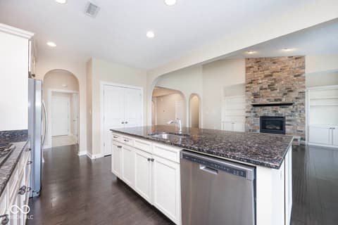 Kitchen at 6257 Strathaven Road, Noblesville, IN — Spacious kitchen with granite island and stone fireplace.
