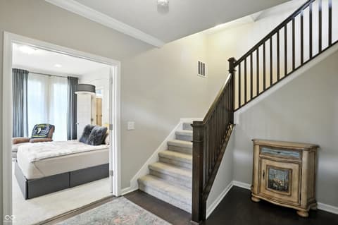Hallway at 13311 Susser Way, Fishers, IN — Elegant staircase with dark railings and neutral tones