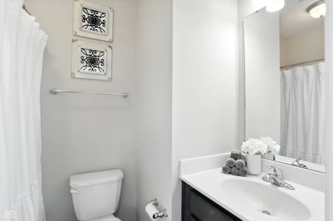 Bathroom at 13311 Susser Way, Fishers, IN — Clean, modern bathroom with dark vanity and white finishes.