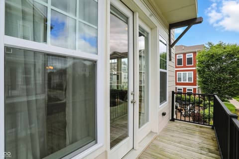 Outdoor living area at 13311 Susser Way, Fishers, IN — Modern deck with expansive glass doors and city views.