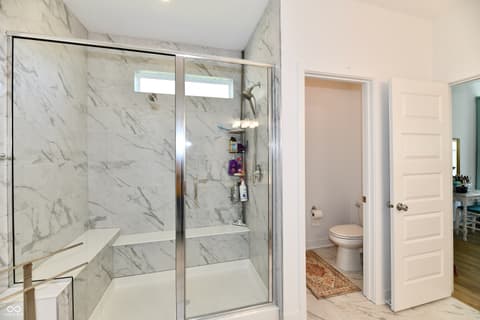 Primary bathroom at 19406 Honeylocust Glen, Noblesville, IN — Luxurious primary bath with marble shower and spa features.