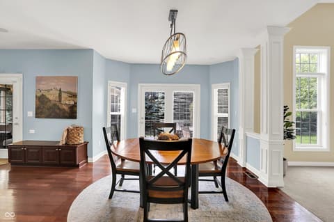 Dining room at 10587 Proposal Pointe Way, Fishers, IN — Bright dining room with curved walls and French doors.