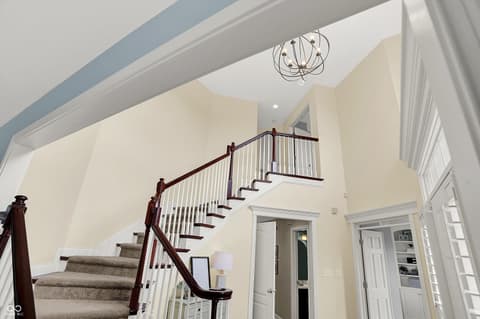 Foyer at 10587 Proposal Pointe Way, Fishers, IN — Elegant foyer with vaulted ceilings and custom staircase.