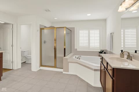 Primary bathroom at 10587 Proposal Pointe Way, Fishers, IN — Luxurious primary bath with dual vanity and soaking tub.