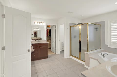 Primary bathroom at 10587 Proposal Pointe Way, Fishers, IN — Spa-like primary bath with soaking tub and walk-in shower.