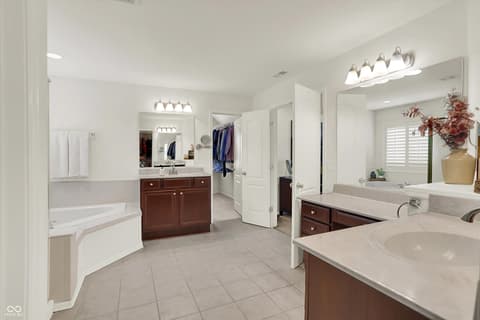 Primary bathroom at 10587 Proposal Pointe Way, Fishers, IN — Spacious primary bath with dual vanities and soaking tub.
