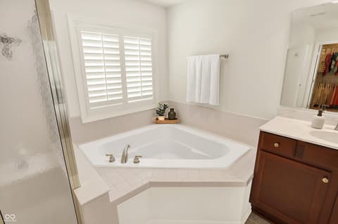 Primary bathroom at 10587 Proposal Pointe Way, Fishers, IN — Bright primary bath with spacious corner soaking tub.