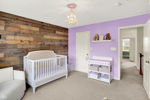 Primary bedroom at 10587 Proposal Pointe Way, Fishers, IN — Beautifully designed nursery with rustic wood accent wall.