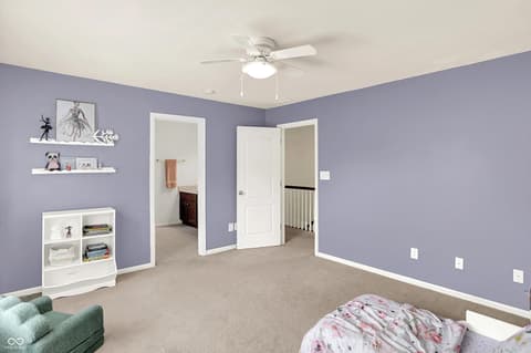 Bedroom at 10587 Proposal Pointe Way, Fishers, IN — Spacious bedroom with purple walls and ample storage.