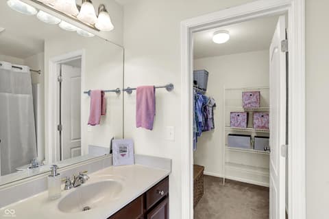Primary bathroom at 10587 Proposal Pointe Way, Fishers, IN — Spacious primary bath with dual vanity and walk-in closet.