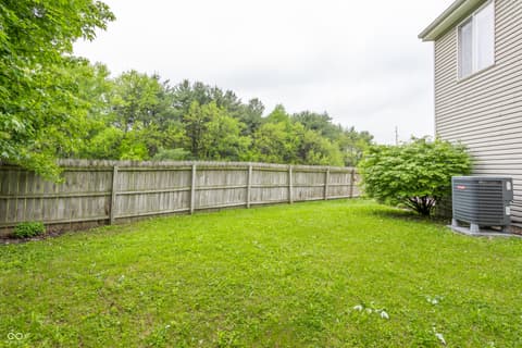 Yard at 9845 Worthington Boulevard, Fishers, IN — Spacious fenced backyard with mature trees and privacy.