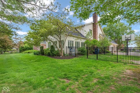 Backyard at 3172 Smokey Ridge Lane, Carmel, IN — Spacious fenced backyard with mature trees and landscaping.