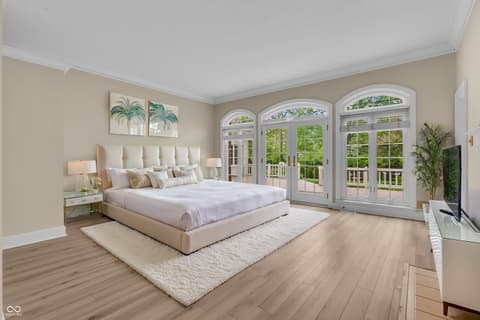 Primary bedroom at 3172 Smokey Ridge Lane, Carmel, IN — Spacious primary suite with arched doors and deck access.