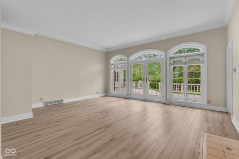 Living room at 3172 Smokey Ridge Lane, Carmel, IN — Bright living room with arched windows and french doors.