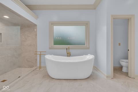 Primary bathroom at 3172 Smokey Ridge Lane, Carmel, IN — Luxurious spa bathroom with freestanding tub and marble.