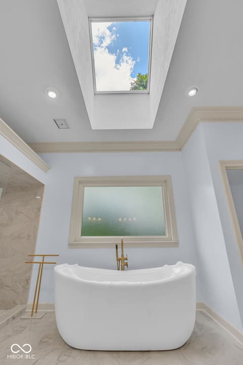 Primary bathroom at 3172 Smokey Ridge Lane, Carmel, IN — Luxurious primary bath with skylight and freestanding tub.
