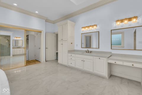Primary bathroom at 3172 Smokey Ridge Lane, Carmel, IN — Luxurious primary bath with dual vanities and marble floors.