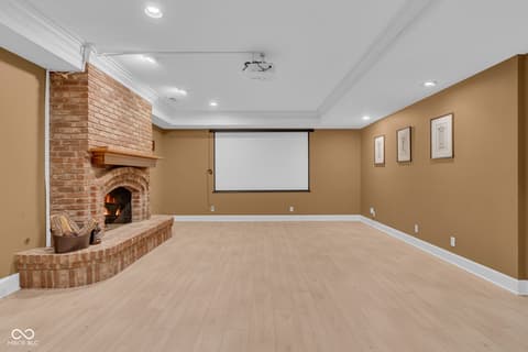 Basement at 3172 Smokey Ridge Lane, Carmel, IN — Finished basement with fireplace and media room setup.