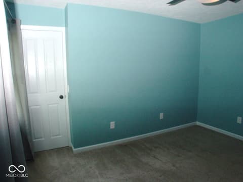Bedroom at 7623 Willow Ridge, Fishers, IN — Spacious bedroom with vibrant turquoise accent walls.