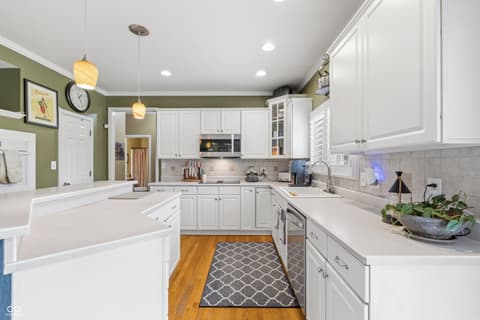 Kitchen at 13221 Griffin Run, Carmel, IN — Bright renovated kitchen with white cabinetry and quartz.
