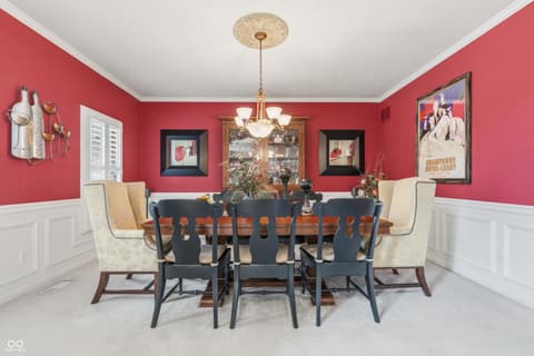 Dining room at 13221 Griffin Run, Carmel, IN — Elegant dining room with bold pink walls and wainscoting.