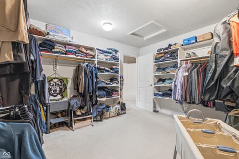 Primary bedroom at 13221 Griffin Run, Carmel, IN — Spacious walk-in closet with extensive built-in shelving.