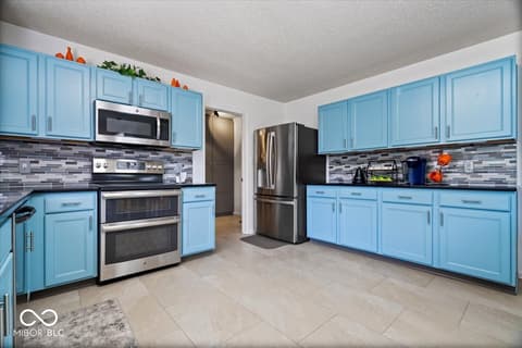 Kitchen at 12667 Courage Crossing, Fishers, IN — Bright blue kitchen with updated stainless steel appliances.
