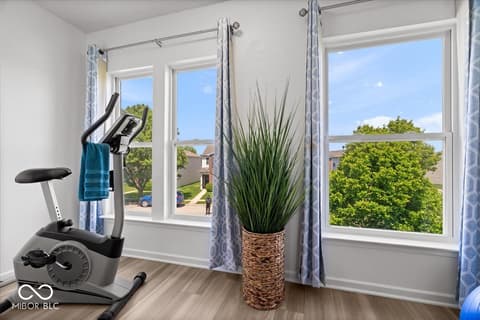 Bonus room at 12667 Courage Crossing, Fishers, IN — Bright bonus room with exercise equipment and scenic views.