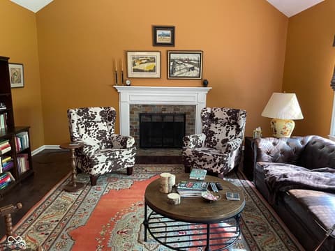 Living room at 3155 Jason Street, Carmel, IN — Elegant living room with fireplace and rich gold walls.